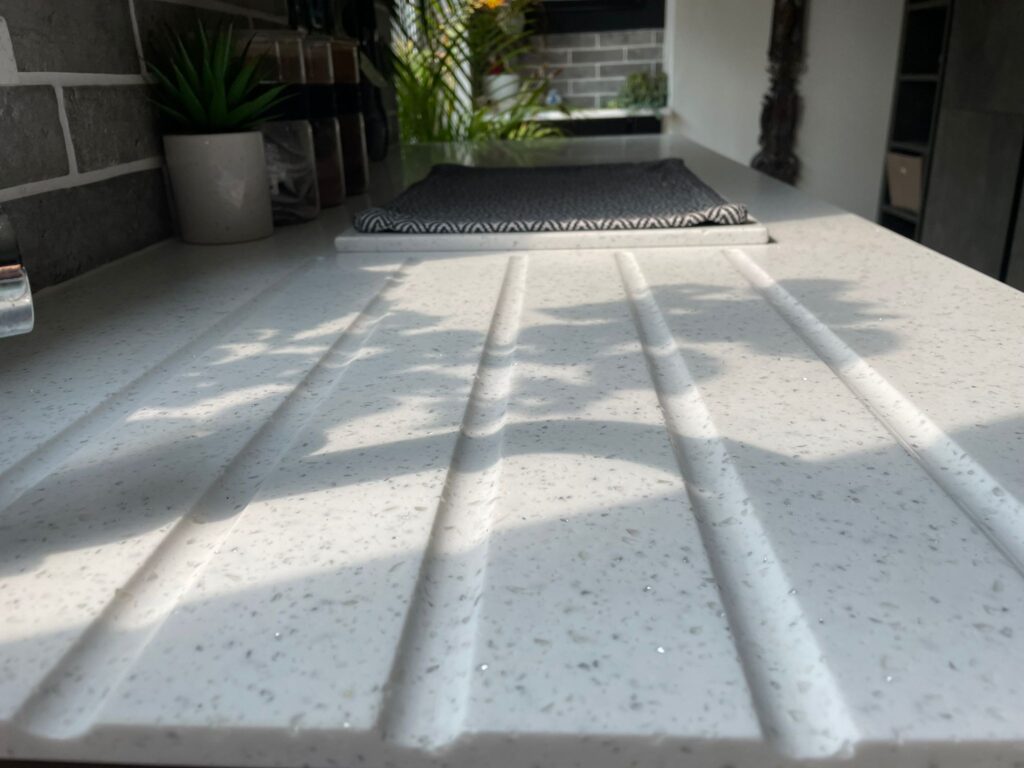 Close up of white speckled quartz worktop with grooves