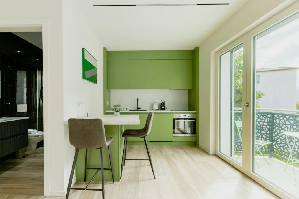 Warm earthy kitchen with green cabinetry and natural light